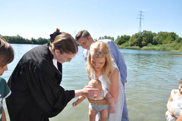 Ein Kind wird von Pfarrerin Katharina Ruhwedel beim Bensheim Tauffest 2022 im Badesee getauft.